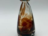 a glass vase with a brown and white swirl inside of it