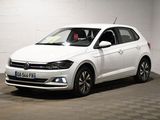 La Volkswagen Polo blanche est garée dans une pièce blanche.