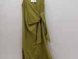a green dress hanging on a hanger on a wall