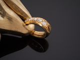 yellow gold ring with diamonds on a black surface