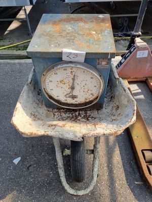 une vieille horloge posée sur une brouette dans un parking