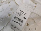 the label on the top of a white dress shows that it has a small amount of lace
