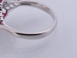 a close up of a ring with a red stone in it