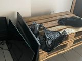 two televisions sitting on a pallet in a room