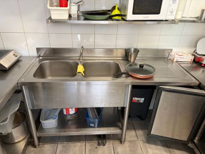 a stainless steel sink in a kitchen with a microwave and dishwasher