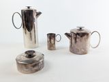 three silver coffee pots and a teapot on a table