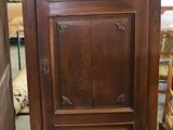 a tall wooden cabinet in the middle of a room