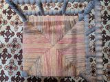 a close up of a wooden chair on a rug with beads