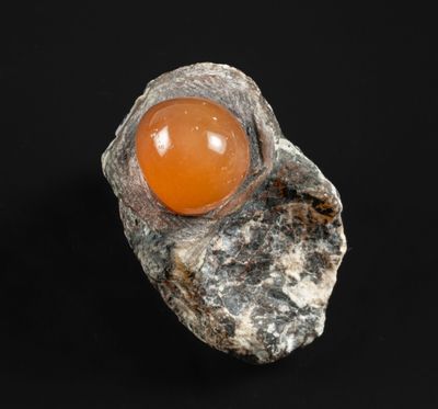 un gros plan d'un rocher contenant une pierre orange