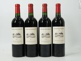 three bottles of red wine are lined up on a white surface