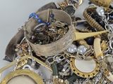 a pile of assorted jewelry on a white surface