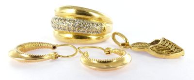 two gold rings and a pair of earrings on a white surface