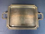 a silver tray with handles and handles on a blue surface
