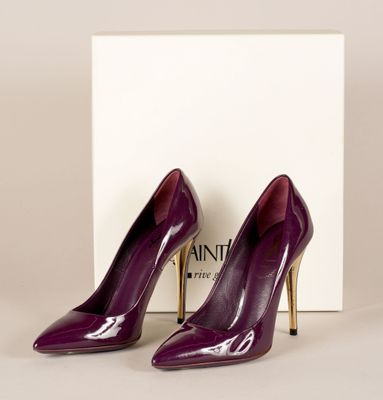 une paire de chaussures à talons hauts violettes posées devant une boîte