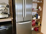 un réfrigérateur en acier inoxydable et une cuisinière noire dans une cuisine