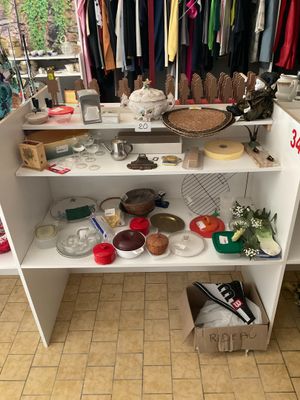 une étagère blanche sur laquelle sont disposés de nombreux objets divers