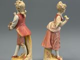 paire de figurines en porcelaine représentant un garçon et une fille assis sur un rocher