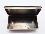 a small metal box with a lid on a white surface