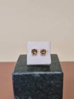 un gros plan sur une paire de boucles d'oreilles posées sur un bloc de marbre