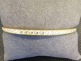 un bracelet en diamants jaunes et blancs posé sur un coussin