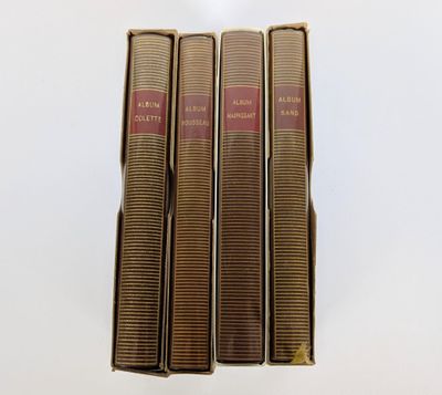 trois livres sont empilés sur une surface blanche