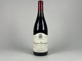 une bouteille de vin rouge posée sur une table blanche