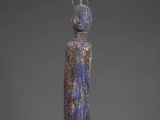 a blue vase with a crown sitting on top of it