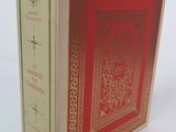 un vieux livre à la couverture rouge posé sur une table blanche