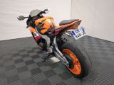 an orange and black motorcycle parked on a black and white checkered floor