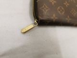 a brown purse with a gold zipper on a white surface