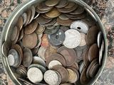 a bowl full of coins sitting on a table next to a bowl of coins