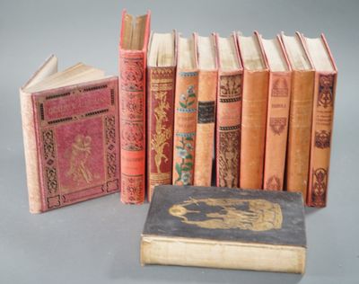several old books are lined up next to each other on a table