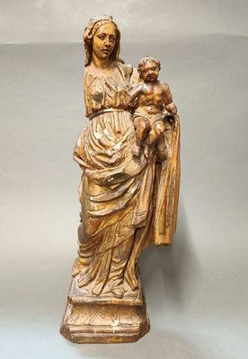 statue en bois représentant une femme tenant un bébé et un chien dans ses bras