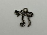 a metal charm with a black and white design on it