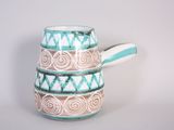 a blue and white pitcher with a handle on a table