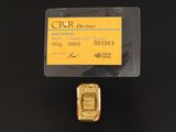 un gros plan sur un lingot d'or auquel est attachée une carte de crédit