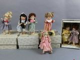 five dolls that are sitting in a box on a table