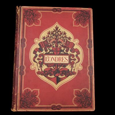 un vieux livre à la couverture rouge posé sur une table