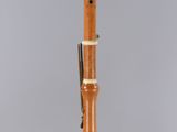 a flute with a wooden body and a wooden handle on a clear surface