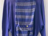 a blue sweater hanging on a hanger next to a white wall
