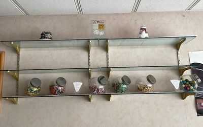 une étagère en verre sur laquelle sont posés tout un tas d'objets