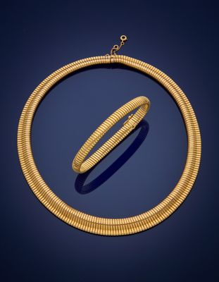a gold necklace and bracelet set on a blue background