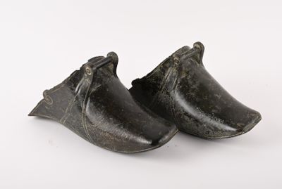 pair of black shoes on a white surface with a white background