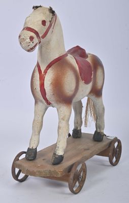 un cheval en bois posé sur une charrette en bois