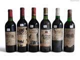 six bottles of wine are lined up in a row on a white surface