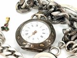 a silver pocket watch with a chain around it
