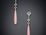 a pair of pink and silver earrings on a black background