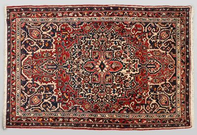 un tapis persan antique avec un motif floral sur fond blanc