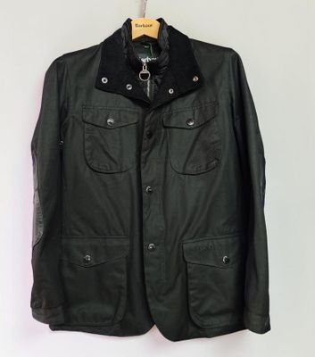 a black leather jacket hanging on a white wall