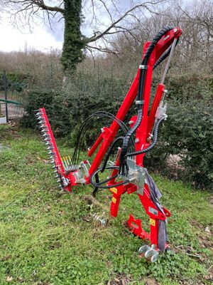 une machine rouge qui est posée dans l'herbe